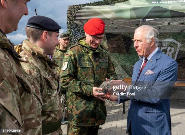 Lieutenant Colonel Dr Stefan Klein and King Charles III exchange gifts as the King visited a Joint Military Unit on March 30, 2023 in Finowfurt,...