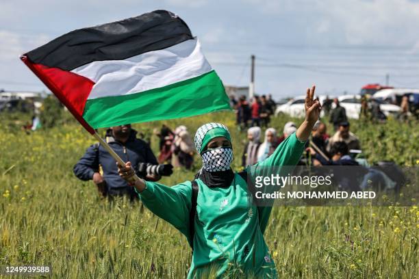 Woman protester waves a Palestinian flag during the 47th annual Land Day demonstration along the Gaza-Israel border east of Gaza City on March 30,...