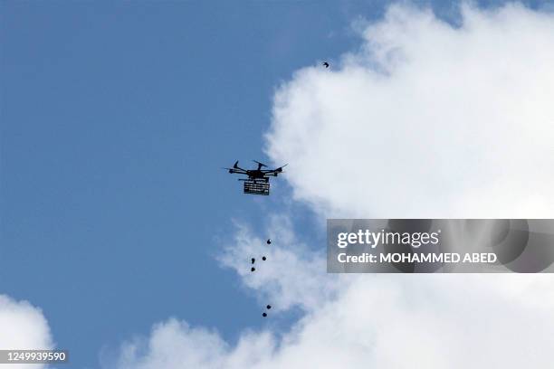 An Israeli drone releases riot-control grenades during clashes between Palestinians and Israeli security forces along the Gaza-Israel border east of...