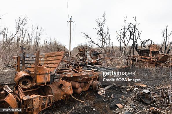 Burnt-out military equipment and mangled burnt trees can be seen at ...