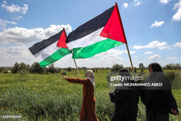 Woman protesters wave Palestinian flags during the 47th annual Land Day demonstration along the Gaza-Israel border east of Gaza City on March 30,...