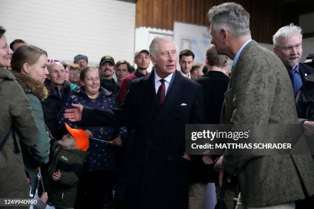 Britain's King Charles III speaks with the manager of the Oekodorf Brodowin eco-village Ludolf von Maltzan as he visits an organic farm with milking...