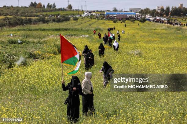 Woman protester waves a Palestinian flag during the 47th annual Land Day demonstration along the Gaza-Israel border east of Gaza City on March 30,...