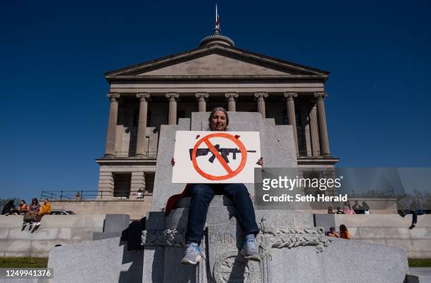 Protester sits with an anti-assault rifle sign near the Tennessee State Capitol to call for an end to gun violence and support stronger gun laws on...