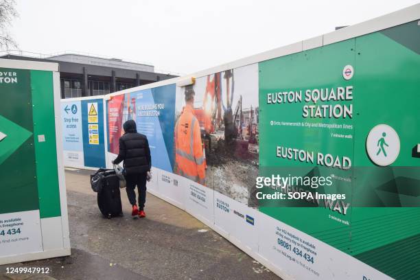 Traveller walks past the HS2 construction site at Euston Station as delays, spiralling costs and uncertainties continue to plague the railway project.