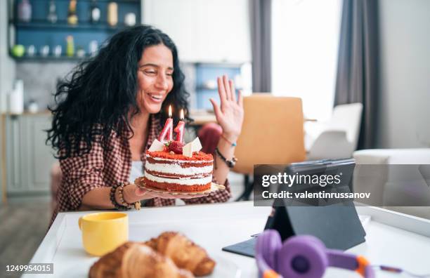 mid adult women celebrating birthday with video conference in home isolation because of pandemic of covid-19 - zoom birthday stock pictures, royalty-free photos & images