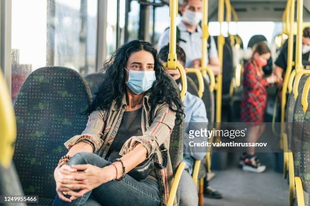 worried woman with protective face mask in the bus,during covid-19 - respiratory disease stock pictures, royalty-free photos & images