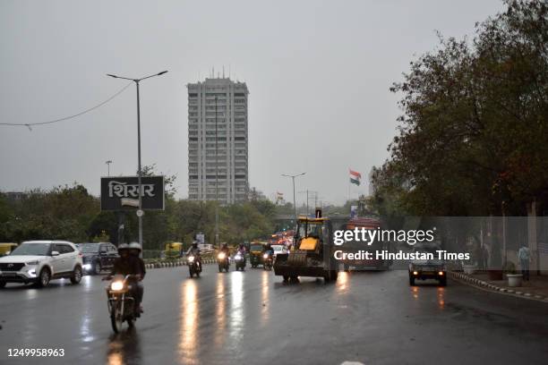 Commuters during heavy rainfall, on March 30, 2023 in New Delhi, India.