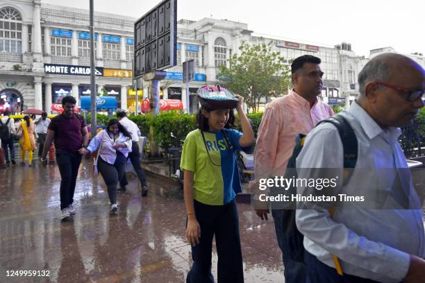 Commuters out during Sudden rain at Connaught Place, on March 30, 2023 in New Delhi, India.