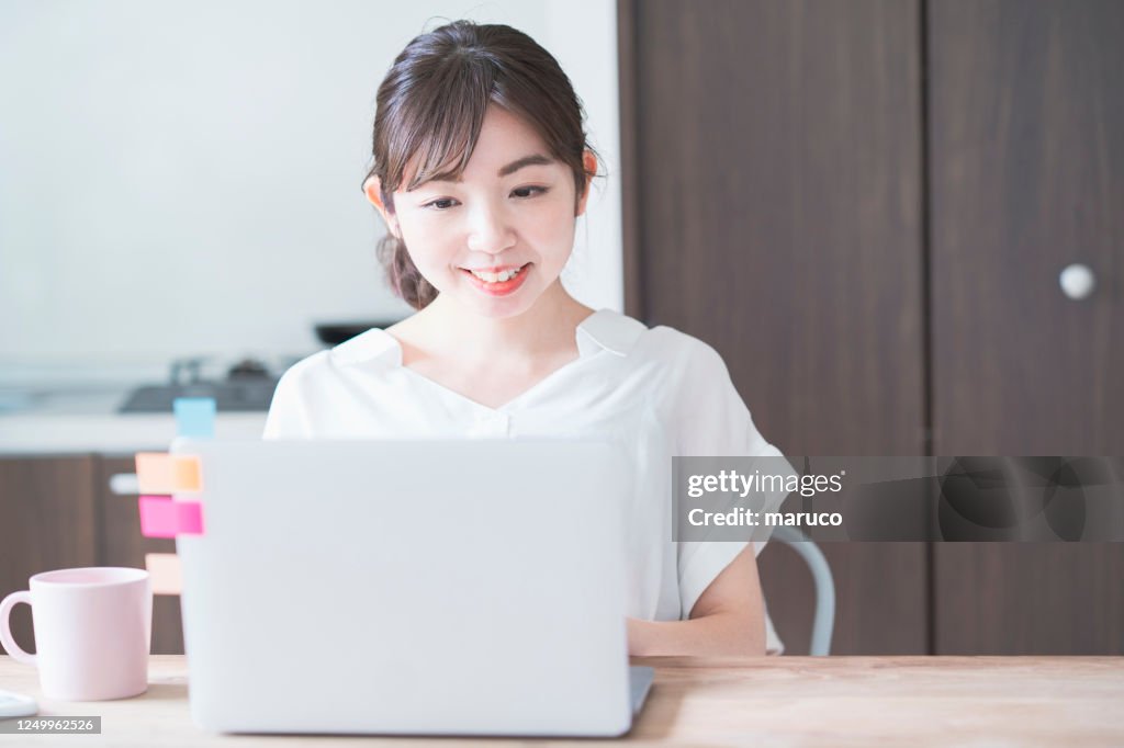 Asiatische Frau macht Remote-Arbeit mit Laptop