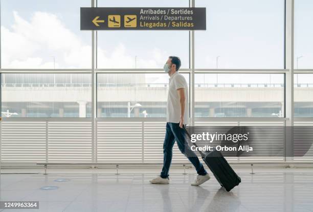 man travelling with face masks for covid-19 - spain coronavirus stock pictures, royalty-free photos & images