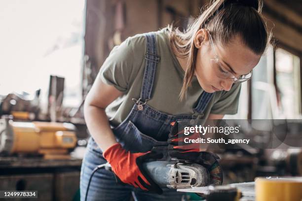 één jonge vrouw die met hoekmolen in workshop werkt - woman sleep stockfoto's en -beelden