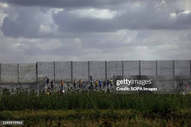 Palestinian protesters attempt to climb the border fence as they gather during the 47th annual Land Day demonstration along the Gaza-Israel border...