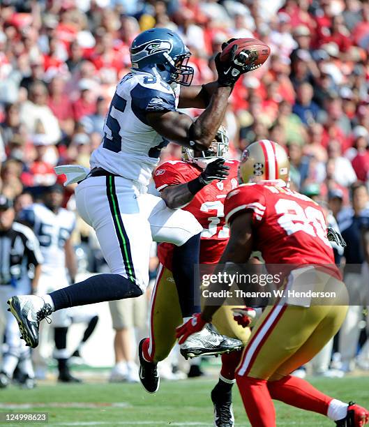 Anthony McCoy of the Seattle Seahawks goes up for a pass between Madieu Williams and Donte Whitner of the San Francisco 49ers during an NFL football...