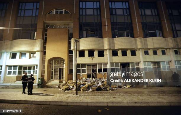 Police officers stand in front of the offices of French satirical magazine Charlie Hebdo on November 2, 2011 in Paris after they were destroyed by a...
