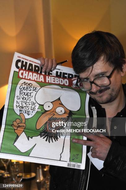 The Charlie Hebdo' s cartoonist Luz shows a special edition of French satirical magazine Charlie Hebdo, on November 3, 2011 during an editorial...