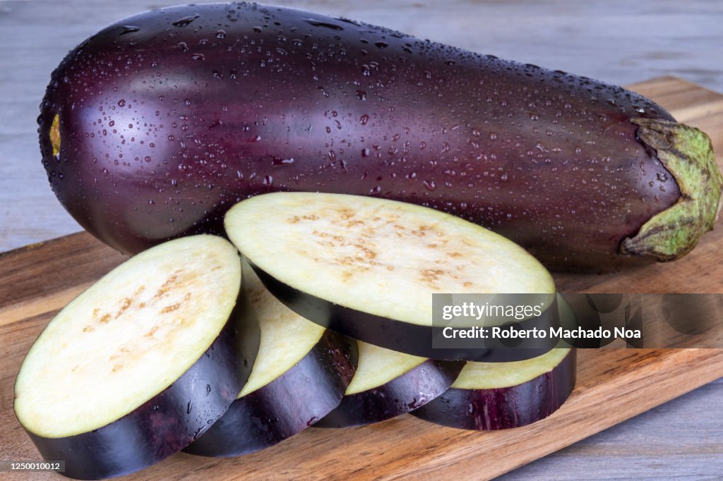 Slices of eggplant on wooden background