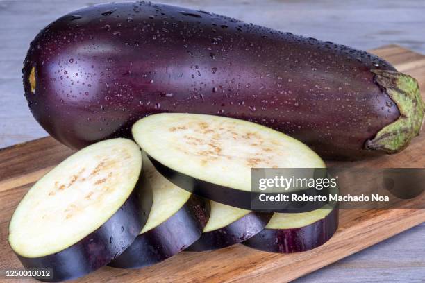 slices of eggplant on wooden background - eggplant stockfoto's en -beelden