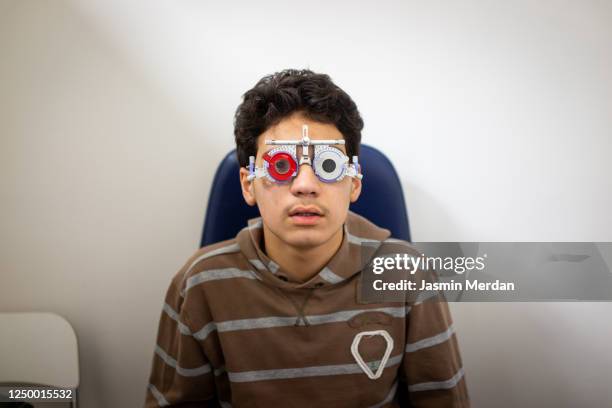 tuning the intrument. boy testing his eyes in the doctor's office - ophthalmologist chart stock pictures, royalty-free photos & images