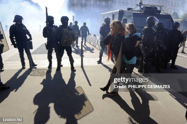 High school student walk past anti-riot police officers during a demonstration in Lyon, southern France, on October 21 to protest against the...