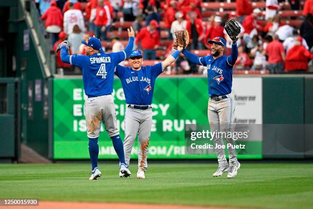 George Springer, Kevin Kiermaier and Daulton Varsho of the Toronto Blue Jays celebrate their teams 10-9 victory over the St. Louis Cardinals on...