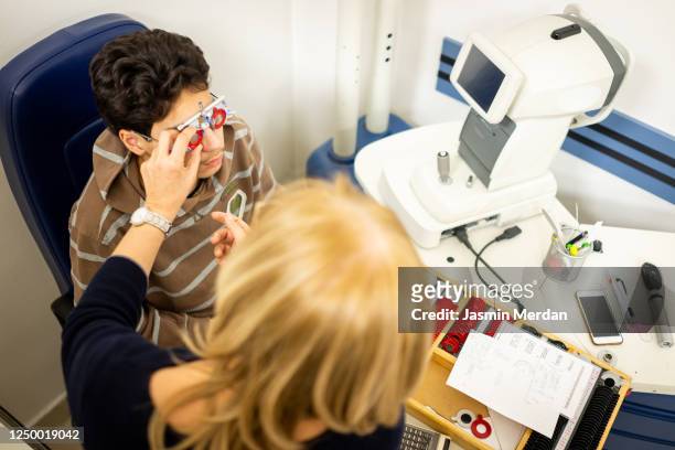 tuning the intrument. boy testing his eyes in the doctor's office - ophthalmologist chart stock pictures, royalty-free photos & images