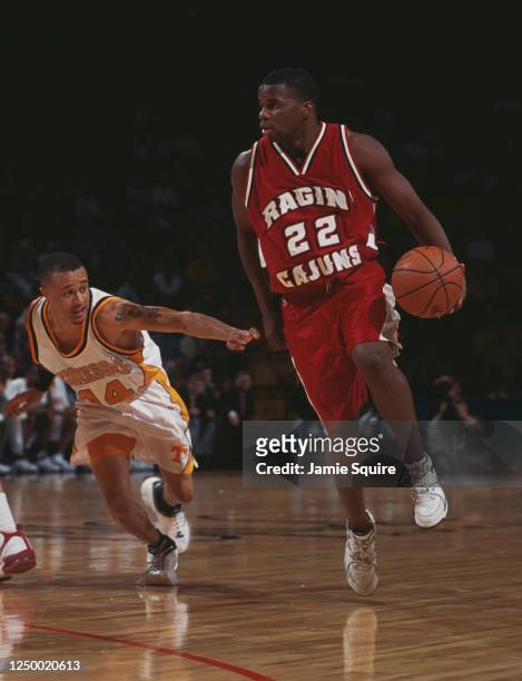 Blane Harmon, Guard for the Louisiana-Lafayette Ragin' Cajuns dribbles the ball past Tony Harris of the University of Tennessee Volunteers during...