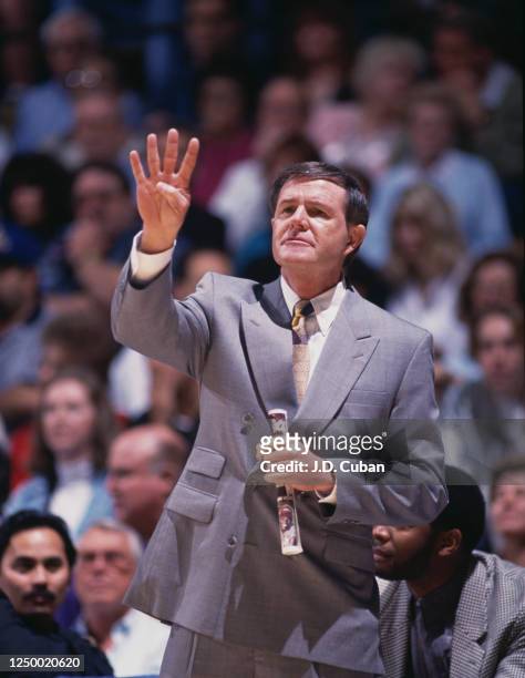 Denny Crum, Head Coach for the University of Louisville Cardinals gives hand signals to pass on instructions to his players during the NCAA Pac-10...