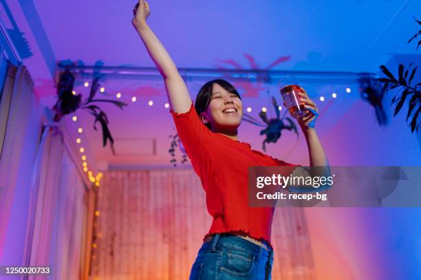 young woman watching online concert and dancing at home - quarantine party stock pictures, royalty-free photos & images