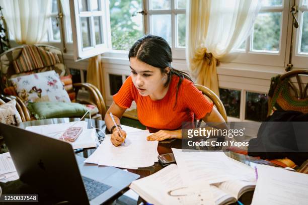 hispanic college student doing some home works from home with laptop - beautiful college girls stock pictures, royalty-free photos & images