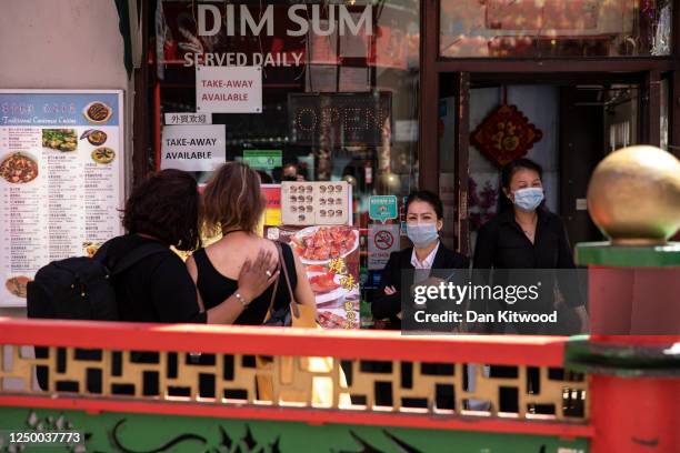 Couple look at a restaurant menu who continue to provide a take away service, in Chinatown on June 16, 2020 in London, England. The Coronavirus...