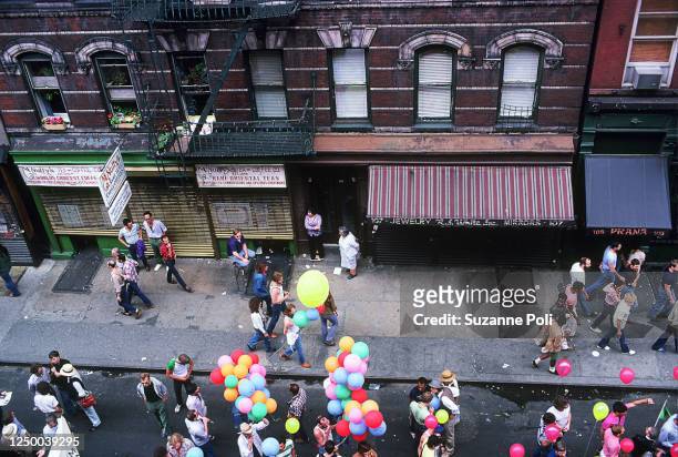 View, from above, of pedestrians and marchers, some with balloons, on Christopher Street during the annual New York City Pride March, New York, New...