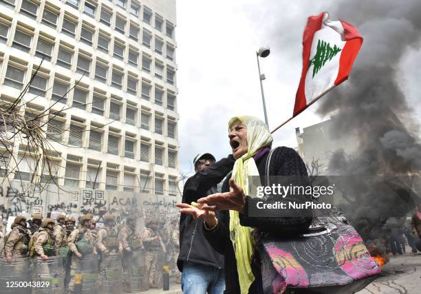 Retired servicemen are removing a razor wire barricade outside Lebanon's central bank during a demonstration demanding inflation-adjustments to their...