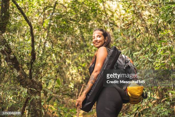 mujer en el bosque mirando hacia atrás - turismo ecológico fotografías e imágenes de stock