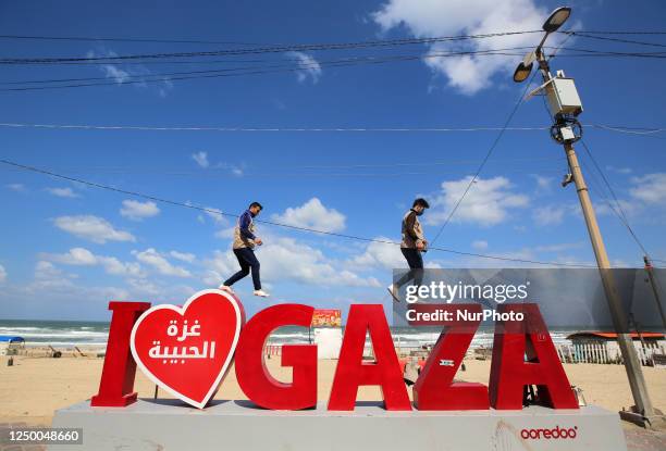 Palestinian young men walk on the coastal road in Gaza City on March 30, 2023.