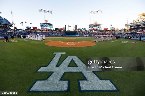 Members of the Los Angeles Dodgers and Arizona Diamondbacks stand on the field prior to the game between the Arizona Diamondbacks and the Los Angeles...