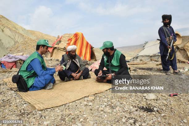 In this picture taken on March 23 census officials from the Pakistan Bureau of Statistics speak to a Marri tribe man living in the remote mountainous...