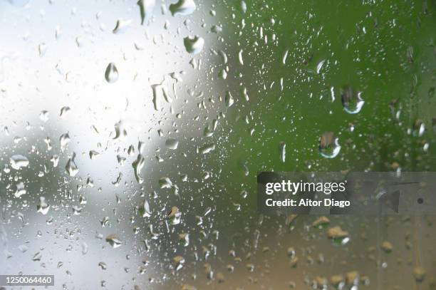 close up of drops of water on a glass in a rainy day. germany. - heavy rain stockfoto's en -beelden