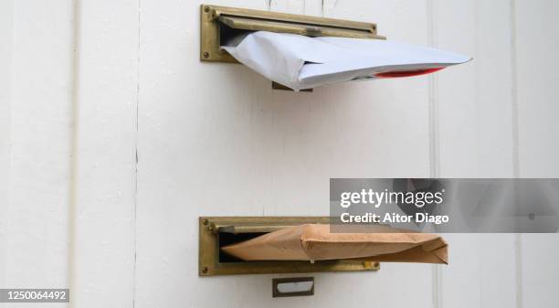 mail packages sticking out of a door mailbox. germany. - ranhura para correio imagens e fotografias de stock