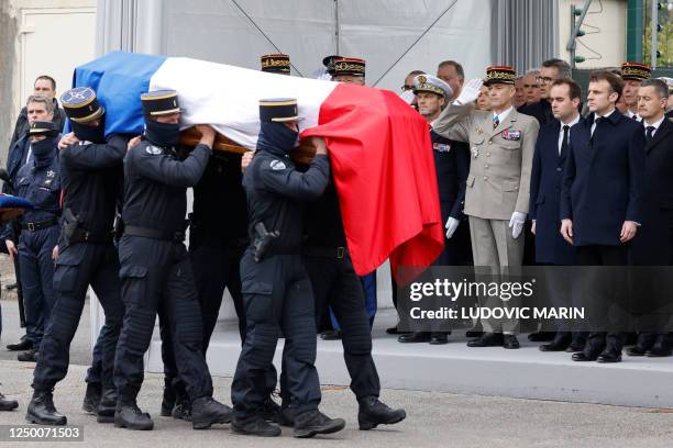 Gendarmes carry the coffin past French President Emmanuel Macron , French Armies Minister Sebastien Lecornu and French Chief of the Defence Staff...