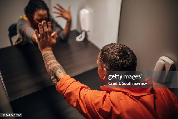 sad wife and her husband sitting in visiting room - black person prison stock pictures, royalty-free photos & images