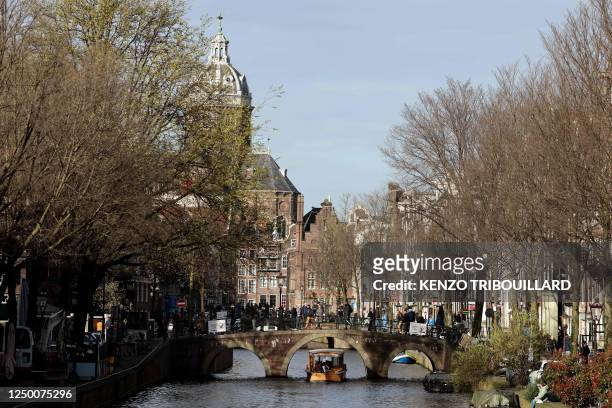 People walk on a bridge in the red light district of Amsterdam on March 30, 2023.