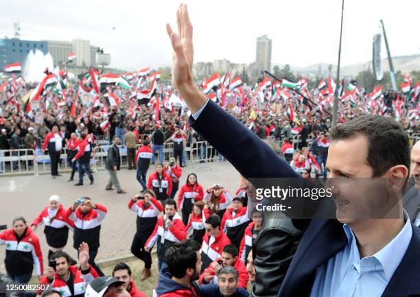 Syrian President Bashar al-Assad waves at supporters during a rare public appearance in Damascus on January 11, 2012 in which he vowed to defeat a...