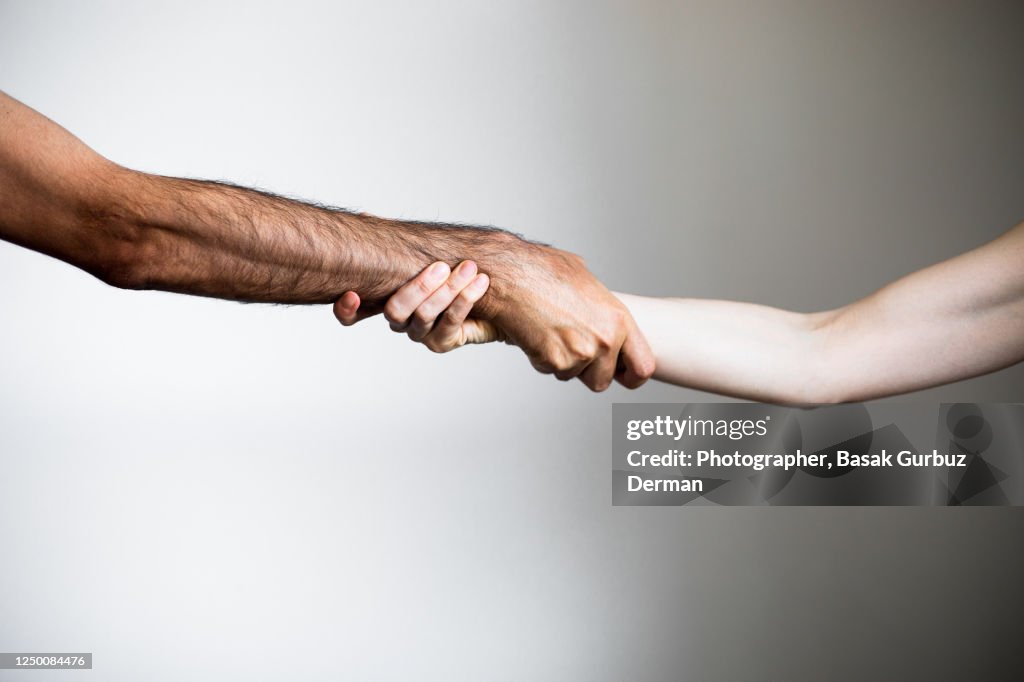 A man and a woman holding hands, engage each other at the wrist