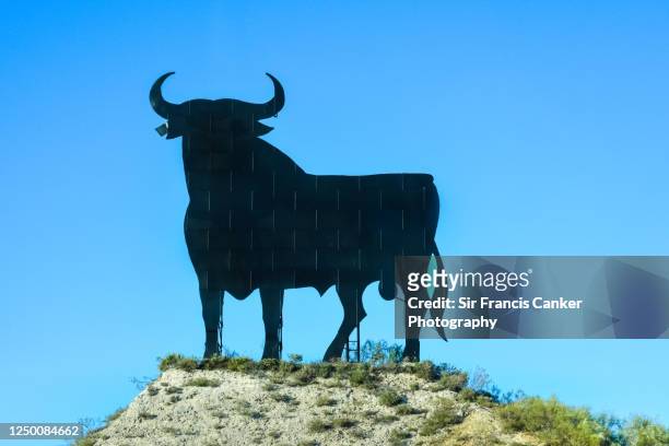 road sign depicting a typical spanish bull on a spanish highway in andalusia, spain - bull billboard spain stock pictures, royalty-free photos & images