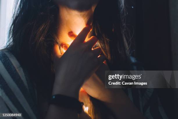 stressed woman with a light shining down her throat with a smart watch - painful lips stock pictures, royalty-free photos & images