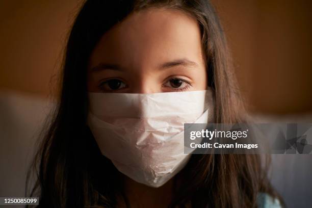 girl with face mask in quarantine at home for covid-19 coronavirus - duct tape face stock-fotos und bilder