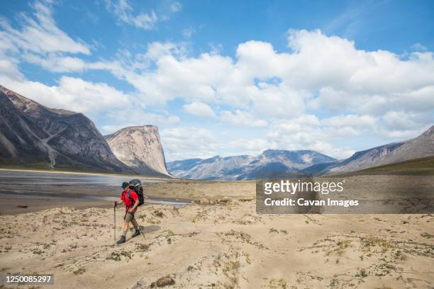 man hiking next to the owl river in akshayak pass - extreme terrain stock pictures, royalty-free photos & images