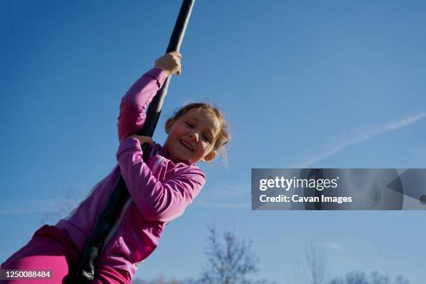 girl on a children's zip line with a blue sky background - eigentliche flughunde gattung stock-fotos und bilder