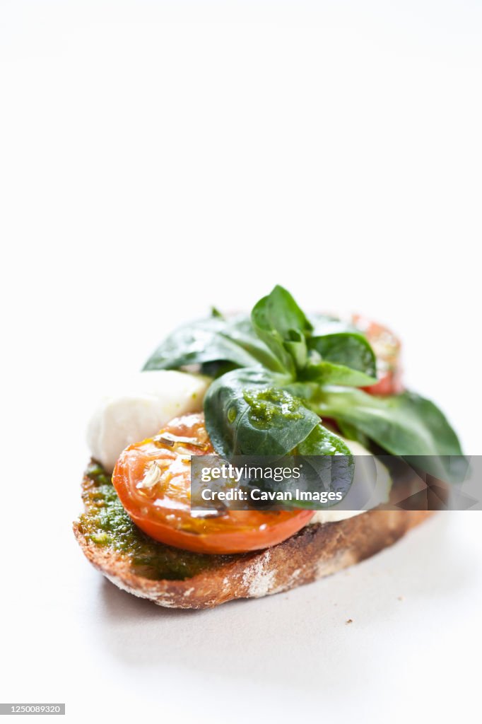 Close up of tomato and mozzarella bruschetta on white background